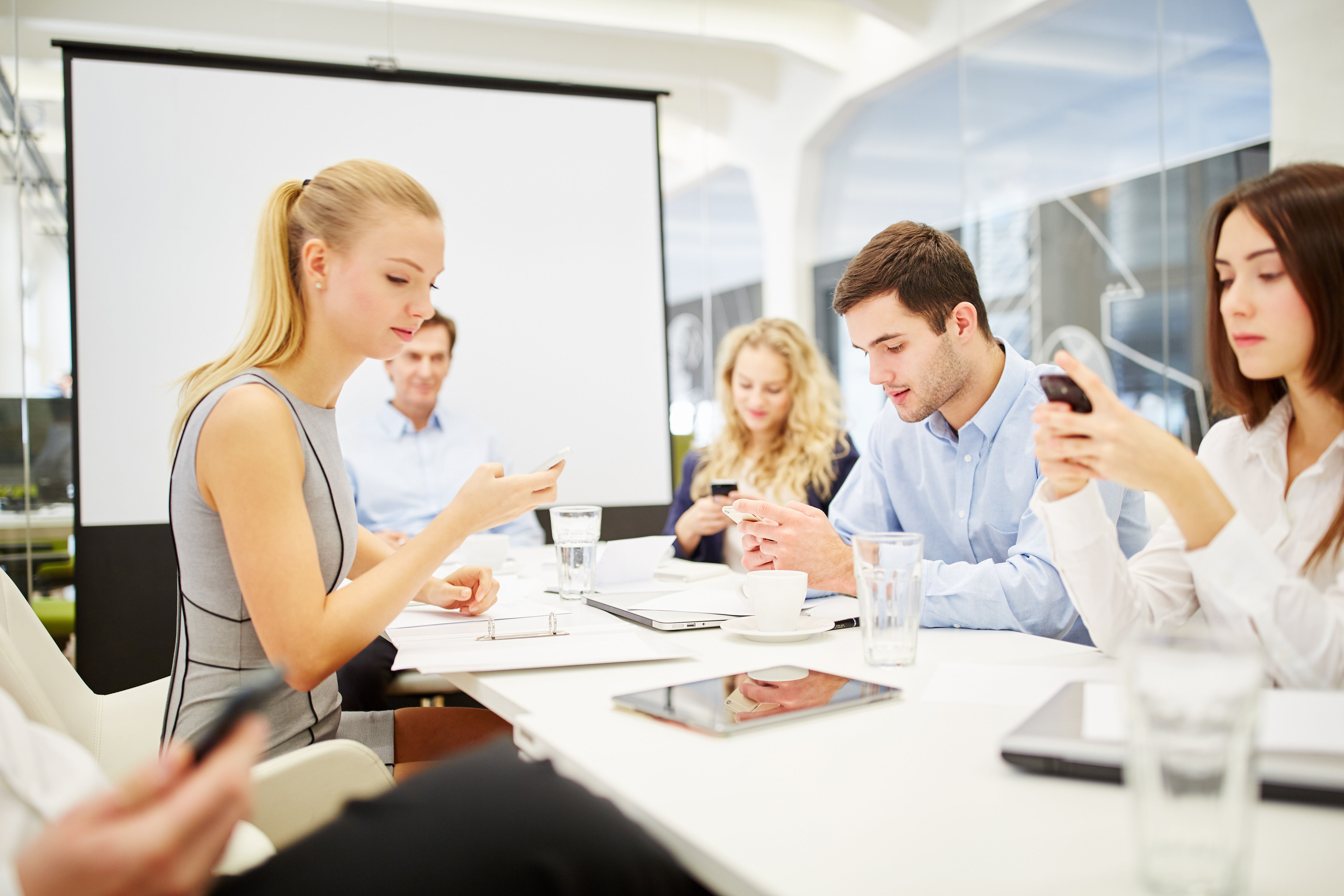 Business people communicating with their smartphones at work.