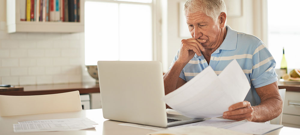 elderly man using laptop to check social security information