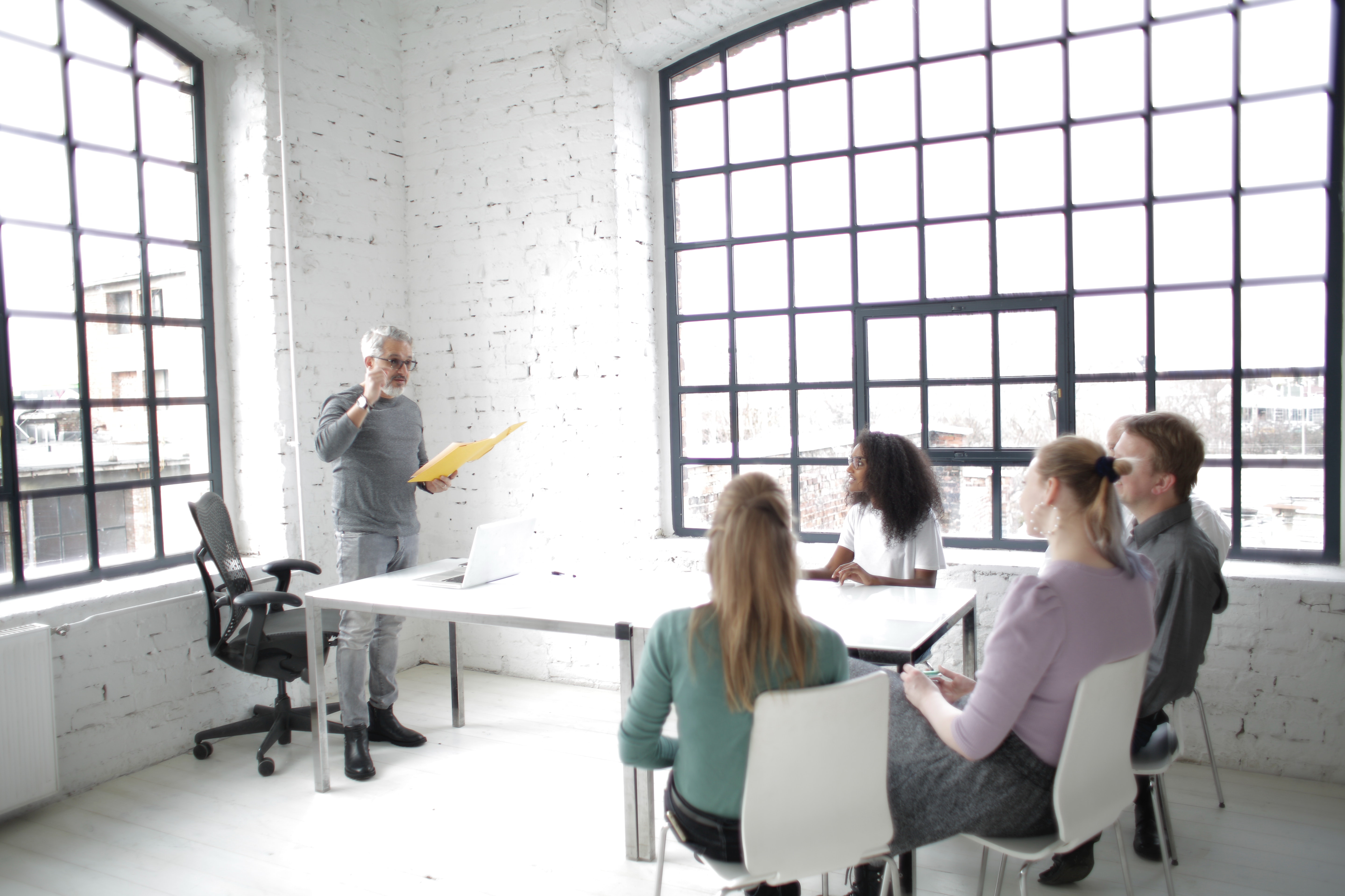 A group of employees sit around a table listening to a presentation on building an audience.