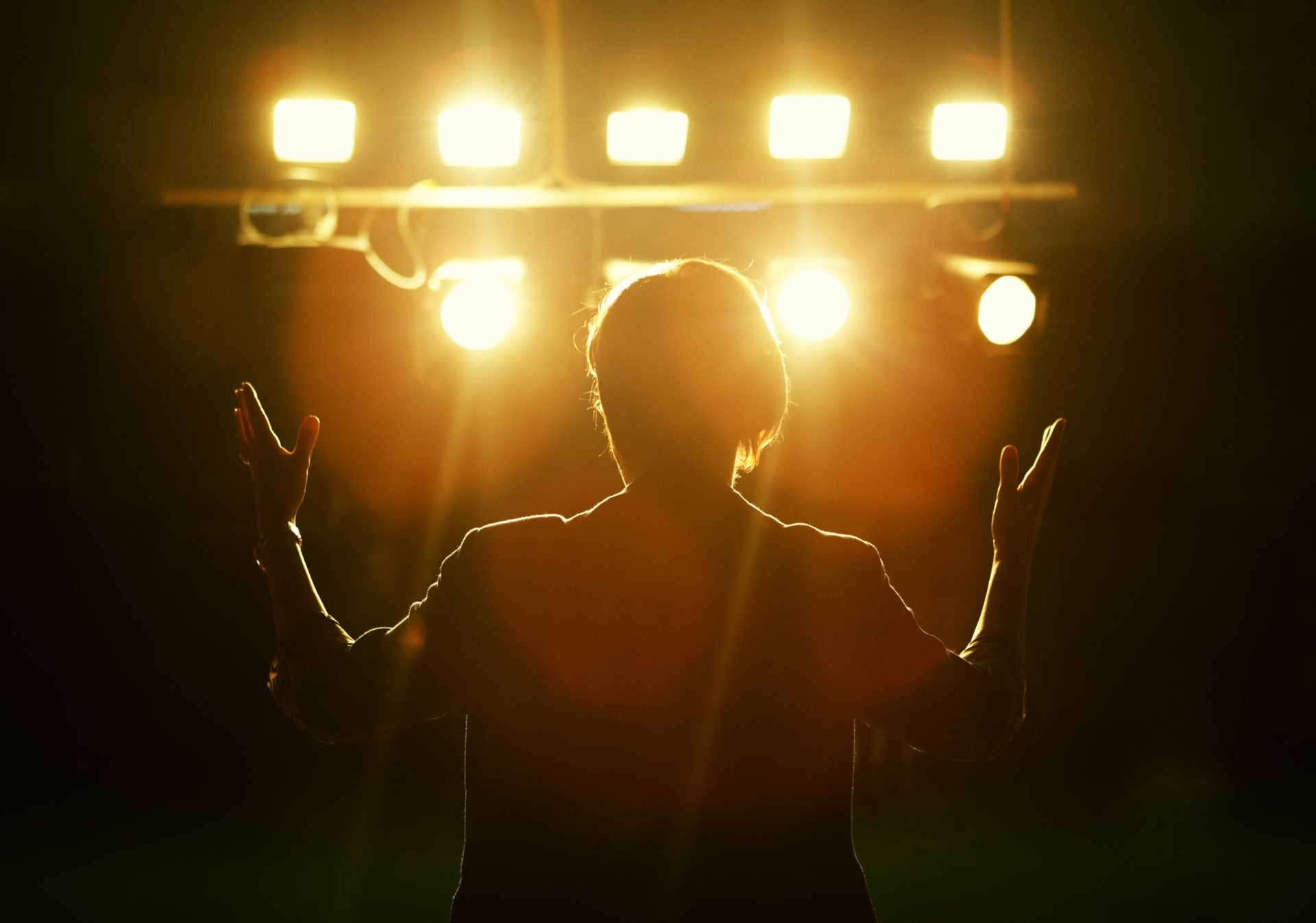 man in spotlights presenting