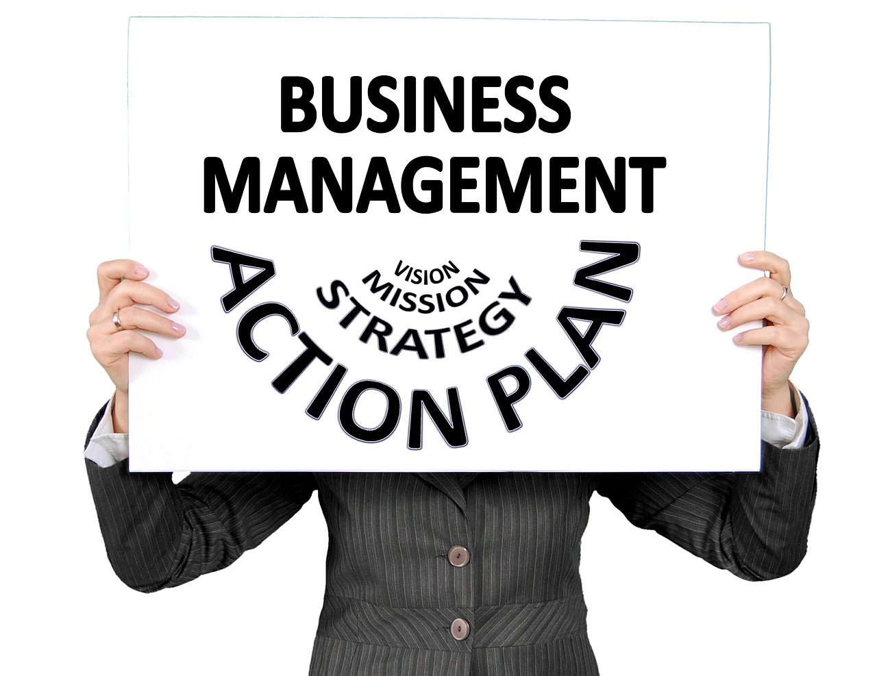 A woman holding up a sign that says, "Business Management vision, mission, strategy, action plan".