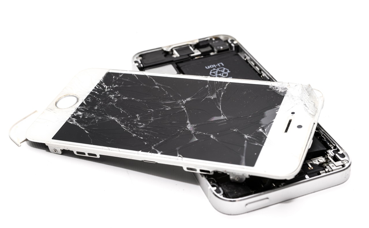 Two broken phones with cracked screens
