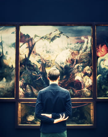 man looking at painting in art gallery
