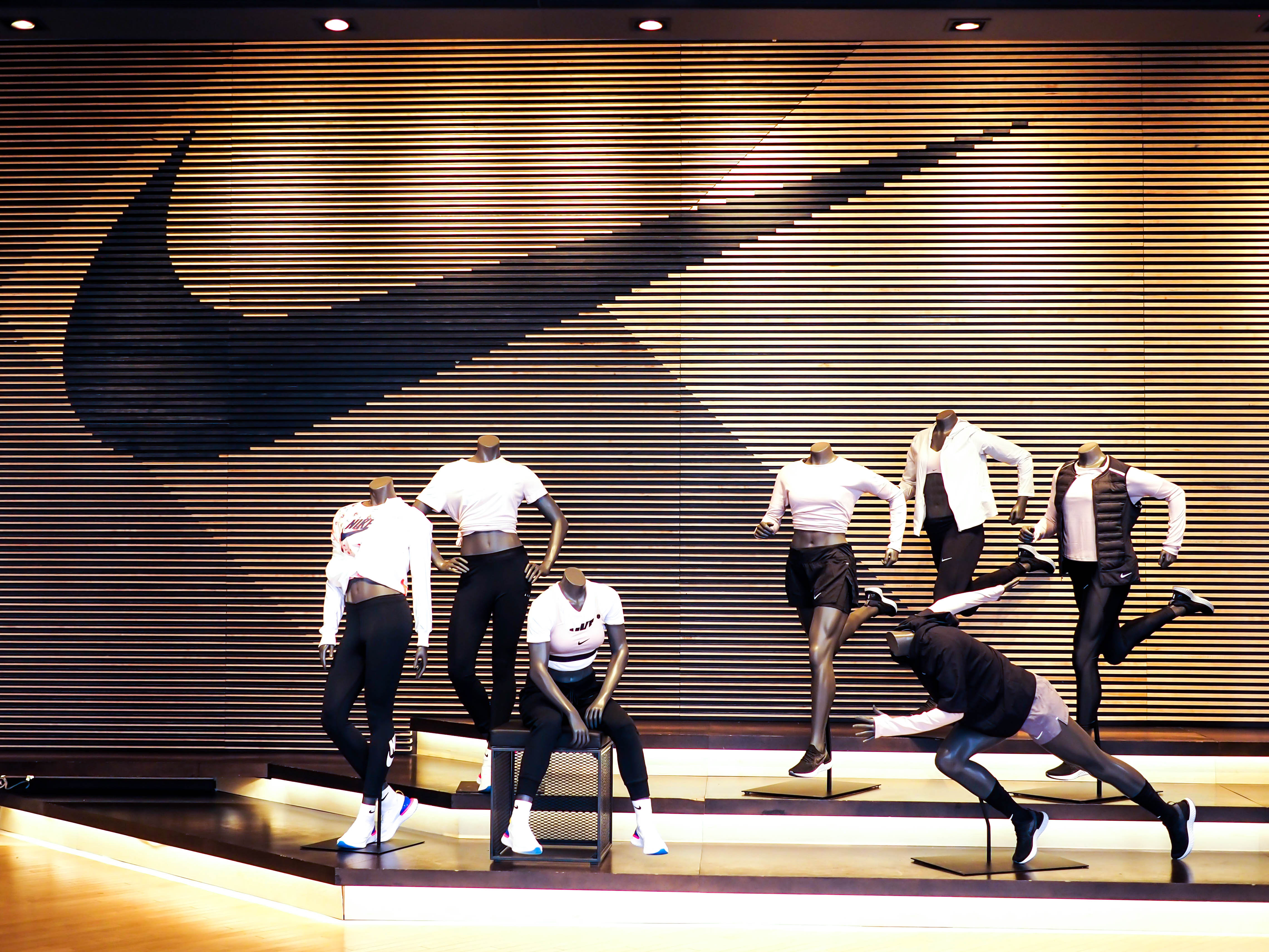 Nike storefront with clothing display and several mannequins demonstrates Nikes branding. 