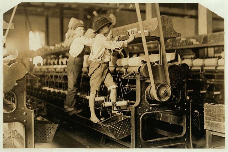 black and white image of child laborers working on looms