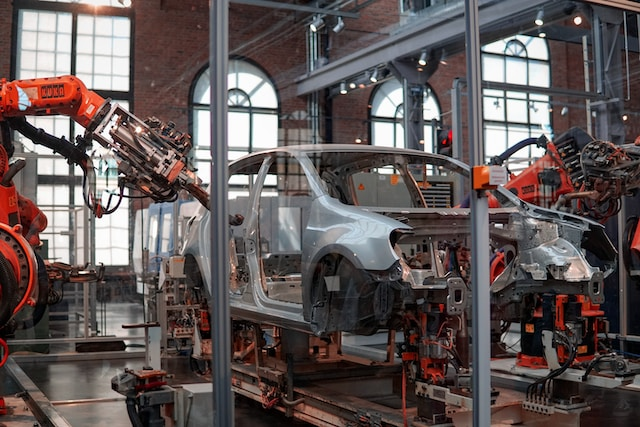 A car being assembled in a factory using a robot.