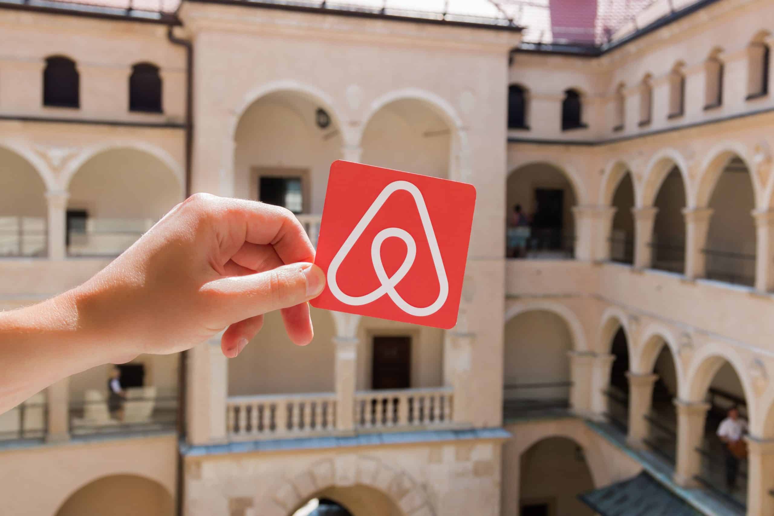 airbnb logo held up in front of a building