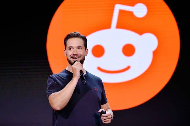 Alexis Ohanian in front of a reddit logo