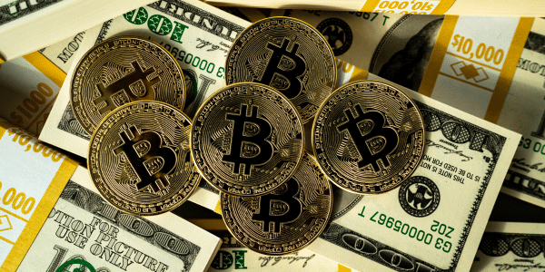 physical bitcoin on top of stashes of us dollars