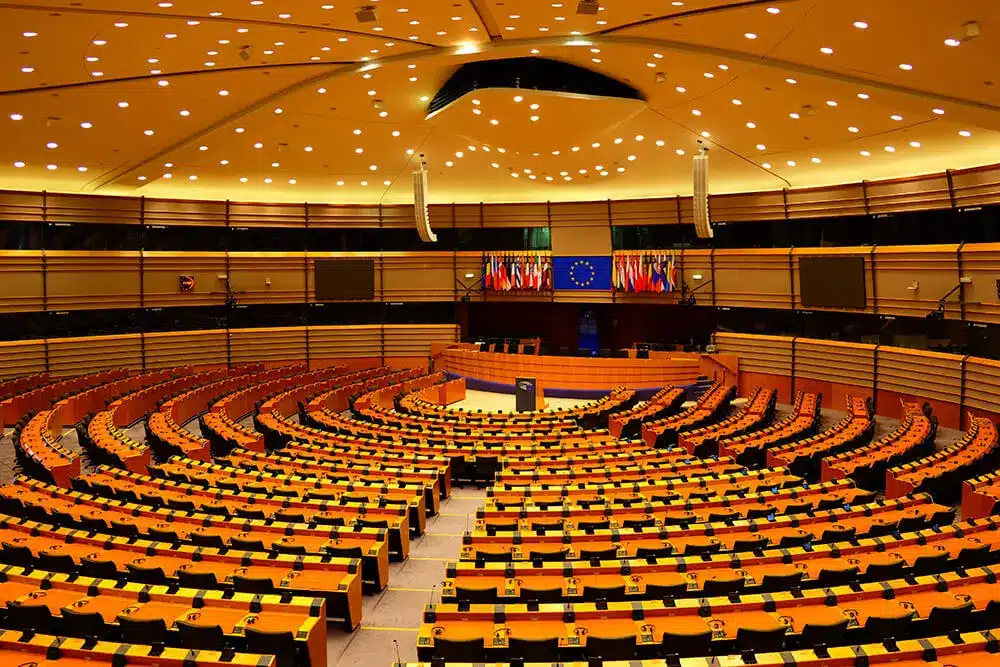 Interior view of the European Parliament chamber in Brussels with empty seating.