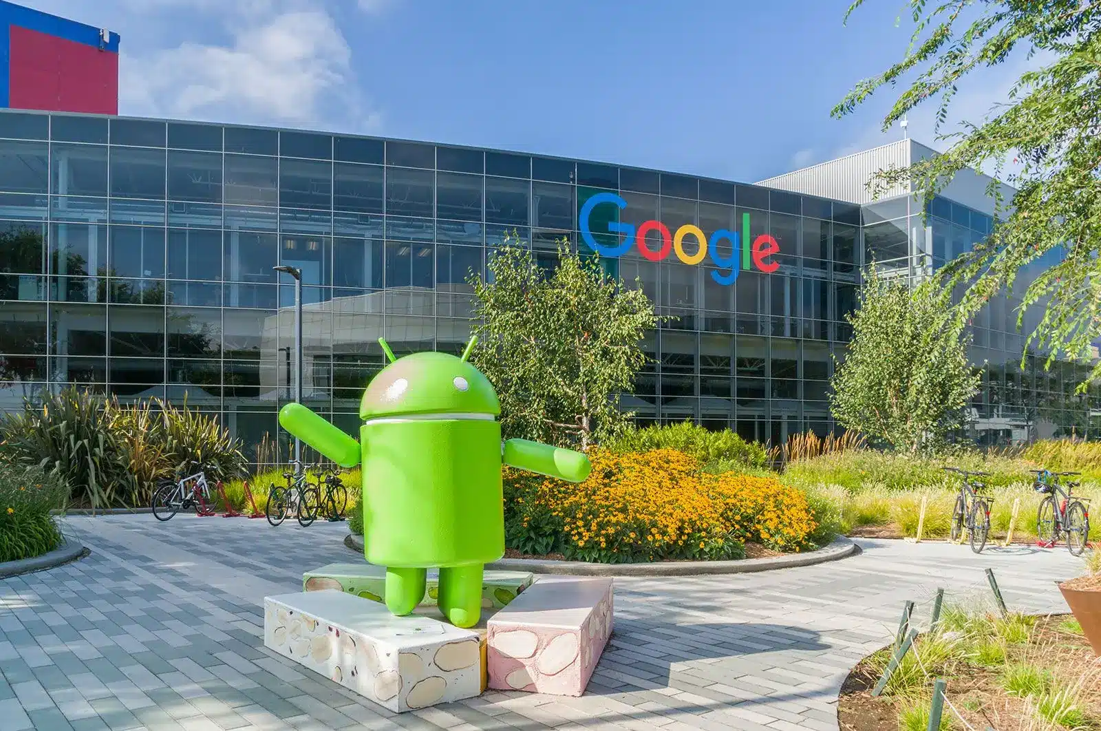 Google headquarters with Android statue in foreground and colorful Google logo.